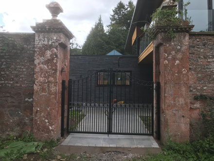 house with black double swinging gates 
