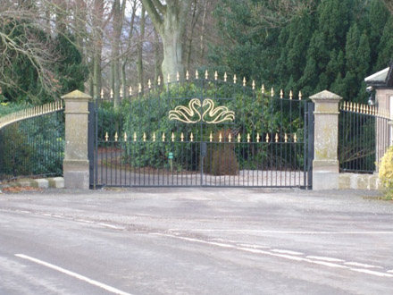 Black and gold driveway gate with swan design