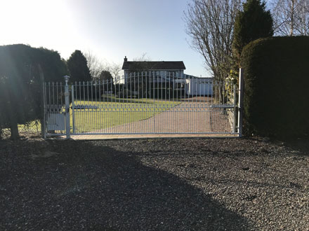 white automated gate at the end of driveway