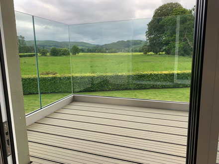 close up of glass balcony and field in background 